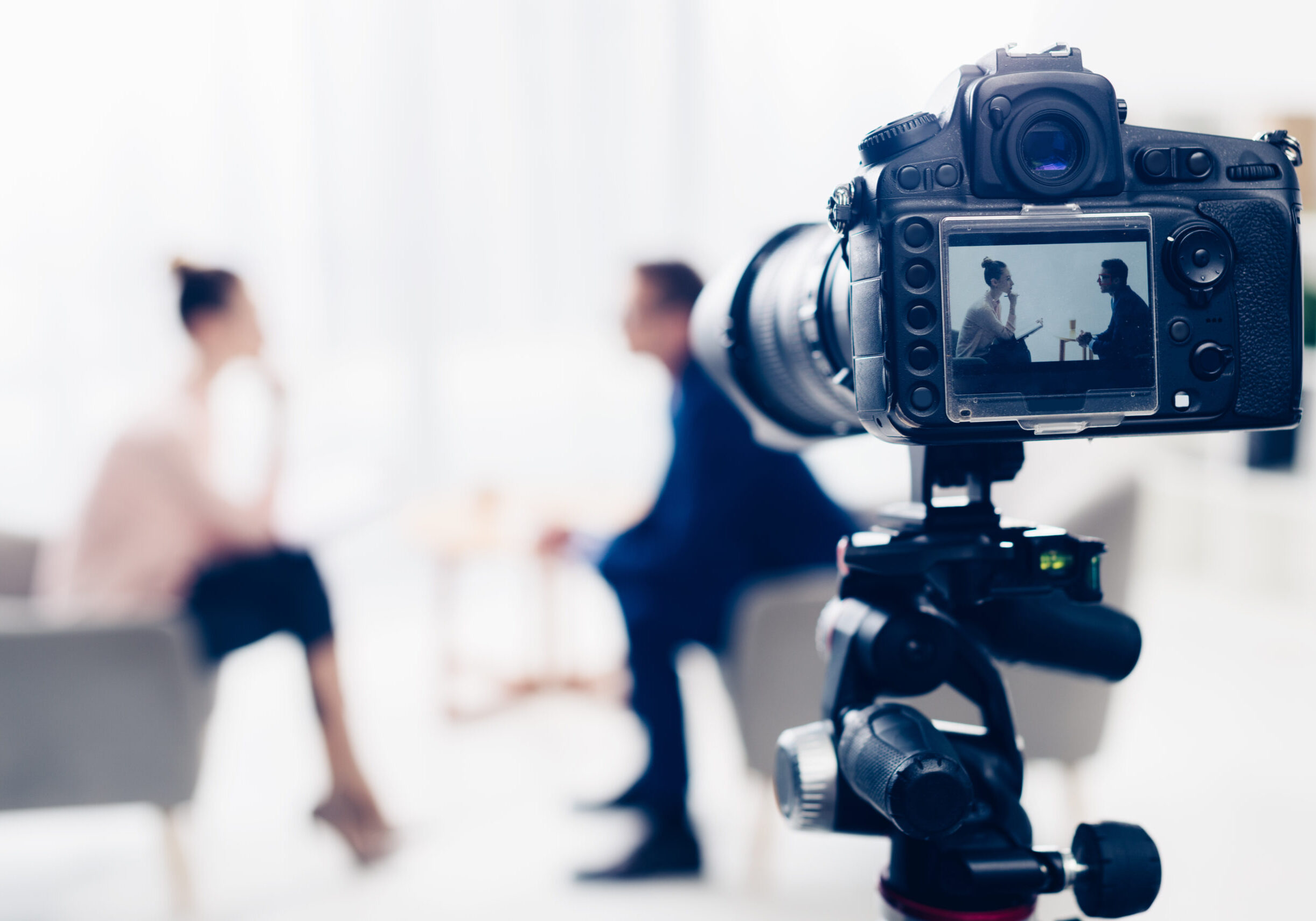 businessman giving interview to journalist in office, camera on businessman giving interview to journalist in office, camera on tripod on foreground