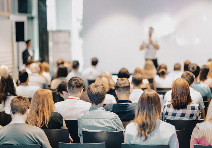 Business speaker giving a talk at business conference event.